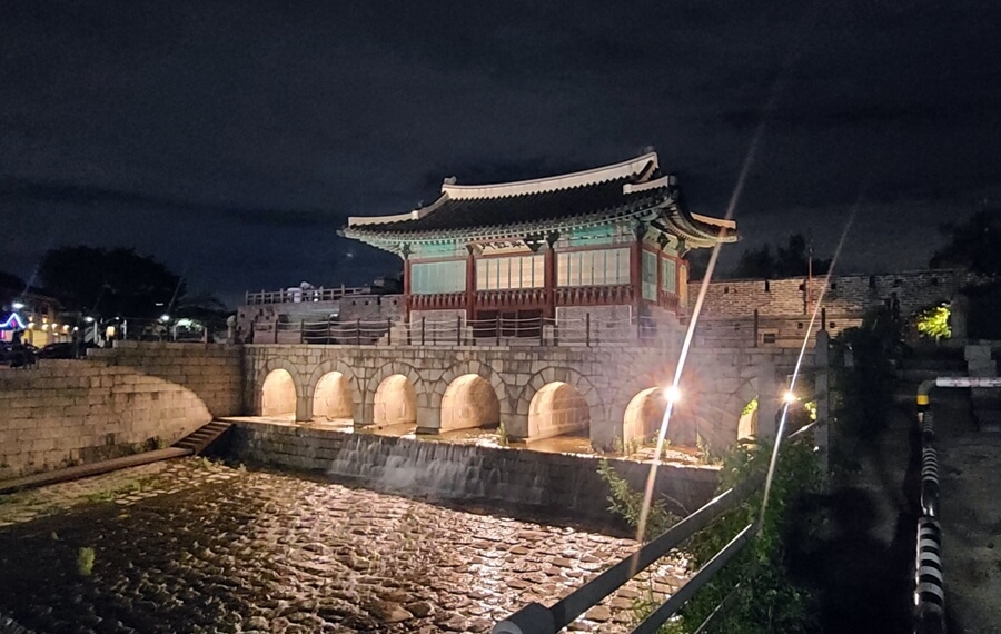 Puente de arcoíris por la noche de Suwon Hwaseong fortaleza